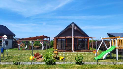 a small house with a playground in the yard at Koniczynka Jarosławiec in Jezierzany