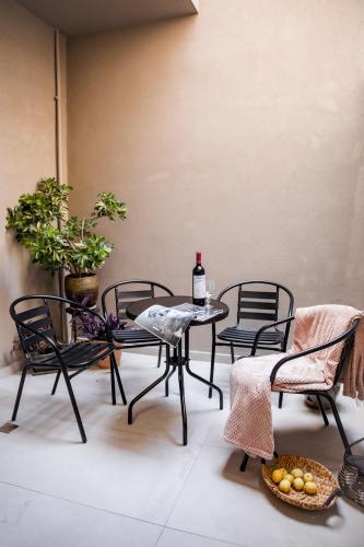 a patio with a table and chairs and a bottle of wine at Magdalena Suite 3.0 in Heraklio Town