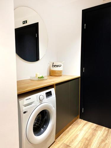 a laundry room with a washing machine and a mirror at Magdalena Suite 3.0 in Heraklio Town