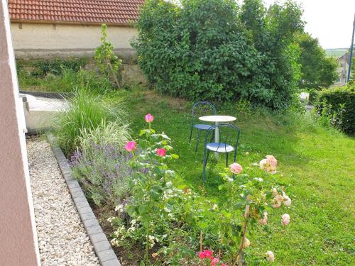 a table and chairs in a garden with flowers at Cozy Place in Müllendorf