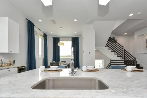 a white kitchen with a sink and a staircase at Casa LaBella - Downtown Skyline Views - Sleeps 10 in Houston