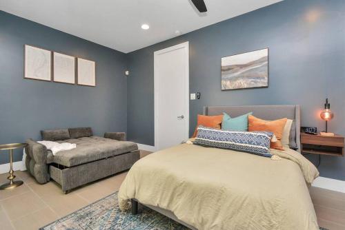 1 dormitorio con 1 cama y 1 silla en Casa LaBella - Downtown Skyline Views - Sleeps 10 en Houston