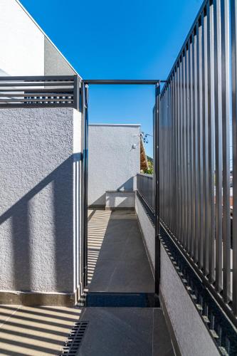 a fence on a sidewalk next to a building at Pousada Casa da Cidinha in Extrema