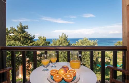a table with two glasses of orange juice on a balcony at Arpyia in Vasilikos
