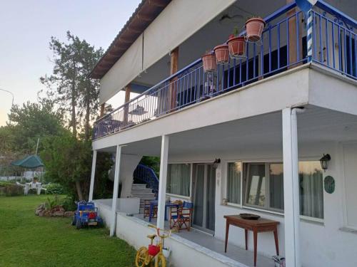 a white house with a balcony and a yard at ALMADOL HOUSE Chalkidiki Τρυπητή Χαλκιδικής in Nea Roda