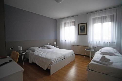 フェルトレにあるAlbergo Alla Cesaのベッドルーム1室(ベッド2台、窓2つ付)