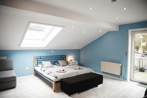 a bedroom with a bed with blue walls and a skylight at Modernes Apartment mit Top Ausstattung und Kamin im Oberpfälzer Seenland in Nittenau