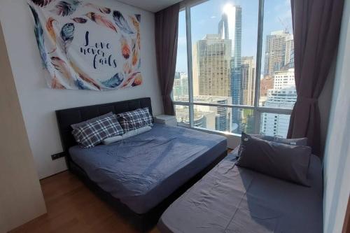 a bedroom with a bed and a large window at 5mins to KLCC -Lvl32-2br-FreeParking in Kuala Lumpur