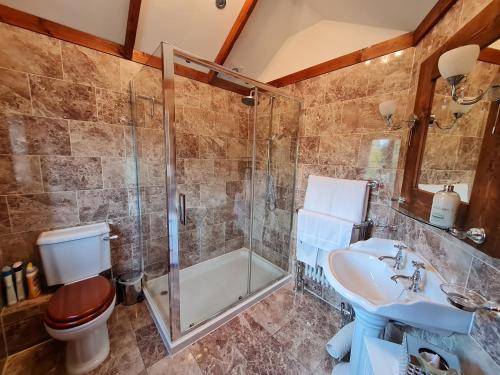 a bathroom with a shower toilet and a sink at Barley View in Aylmerton