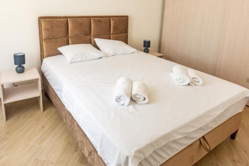 a bedroom with a bed with towels on it at White Apartment in Kumbor