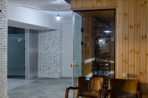 a room with two chairs and a glass door at Panorama Kvariati in Kvariati