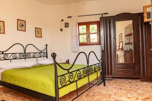 a bedroom with a bed with a yellow bedspread at MaciliaVilla. in Ierápetra