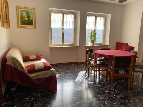 a room with a table and chairs and windows at Civicocentouno in Settimo Vittone