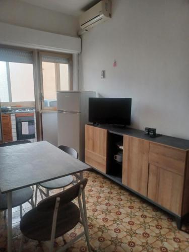 a living room with a table and a tv and a kitchen at Casa al centro in Palermo