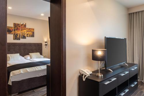 a bedroom with a bed and a tv and a phone at Hotel Central Beach 9 in Makarska