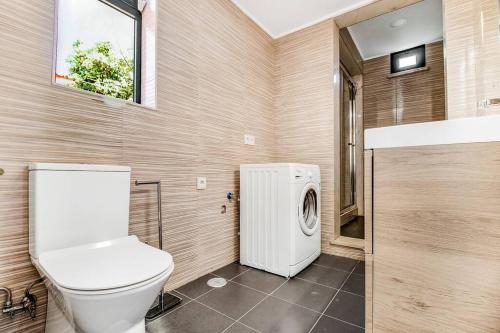 Un baño con inodoro y lavadora. en Ap. Vila Oeiras 5m a pé da praia, en Oeiras