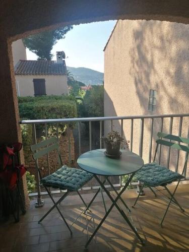 une table et deux chaises sur un balcon dans l'établissement Proche de la plage les hauts du port, à Saint-Cyr-sur-Mer
