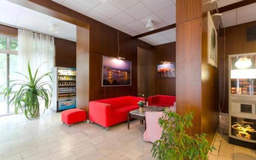 a lobby with red couches and plants in a building at Hermina Apartmanok in Budapest