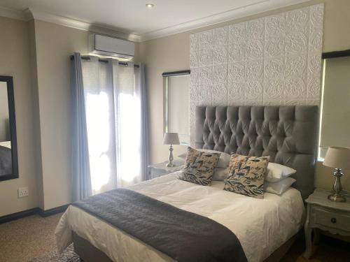 a bedroom with a large bed with a large headboard at Riverfront Golf Estate House in Parys