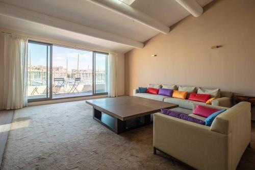 uma sala de estar com um sofá e uma mesa em Sublime Pépite Vieux Port 2p Vue Imprenable em Marselha