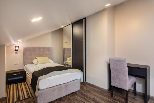 a small bedroom with a bed and a chair at Hotel Central Beach 9 in Makarska