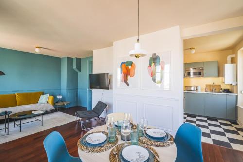 een woonkamer met een tafel en blauwe stoelen bij Blue Velvet Reims in Reims