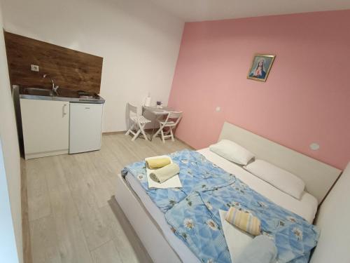 メジュゴリエにあるRooms Marioのベッドルーム1室(ベッド1台付)、キッチン、テーブルが備わります。