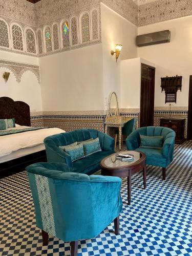 a hotel room with a bed and two chairs and a table at Le Grand Alcazar - Riad in Fès