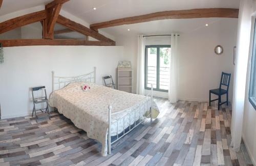 ein Schlafzimmer mit einem Bett und Stühlen in einem Zimmer in der Unterkunft Vacances canal du midi in Ouveillan