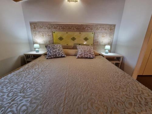 a bedroom with a large bed with two tables at Country house Dolce Nocciola in Vignanello