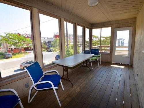 a table and chairs in a room with windows at Surf Club Oceanfront Hotel in Dewey Beach