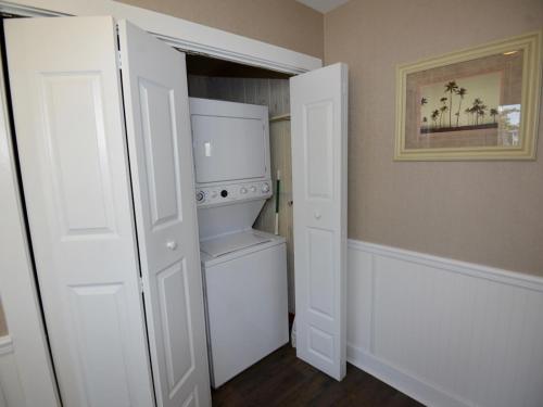 a kitchen with white cabinets and a white refrigerator at Surf Club Oceanfront Hotel in Dewey Beach
