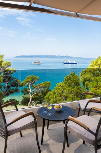 a table and chairs on a balcony with a view of the ocean at Hotel Central Beach 9 in Makarska