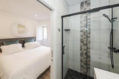 a bedroom with a bed and a glass shower at Silver Coast Retreat in Nazaré