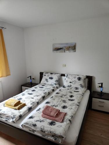 a bed with black and white sheets and pillows at Apartma Nena in Bovec