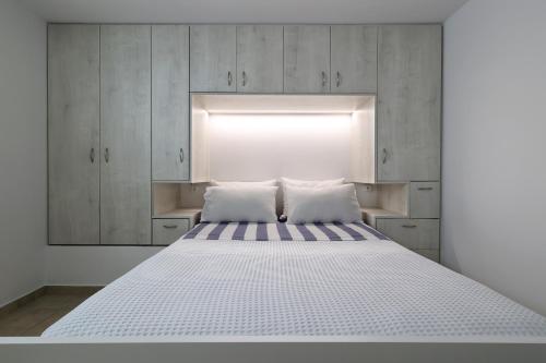 a bedroom with a bed with a light above it at V.A.G.I.A. Apartment in Vaia