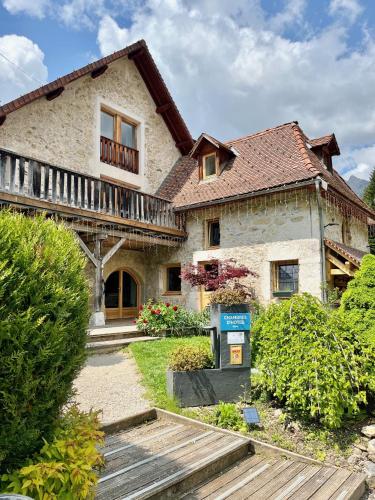 a stone house with a wooden walkway in front of it at Le Valombré in Saint-Pierre-de-Chartreuse