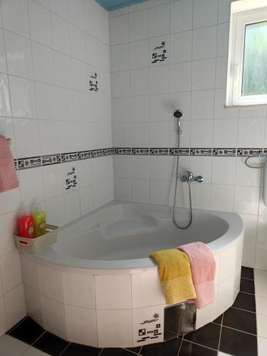 a white bath tub in a white tiled bathroom at Apartma Nena in Bovec