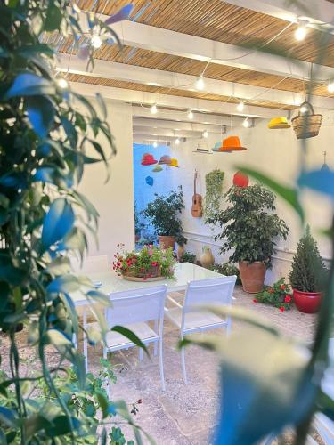 a patio with a white table and chairs and plants at Suite Battisti 7 in Lecce