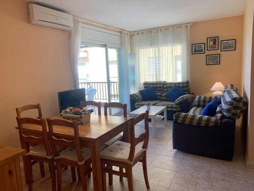 sala de estar con mesa, sillas y sofá en Apartamento Primera Línea de Playa Port-Segur, en Segur de Calafell