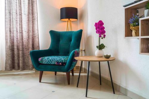 a green chair next to a table with a vase of flowers at Luxury rooms Alice in Split