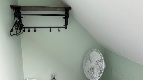 a bathroom with a white fan on a wall at Homestay in Walsall in Walsall
