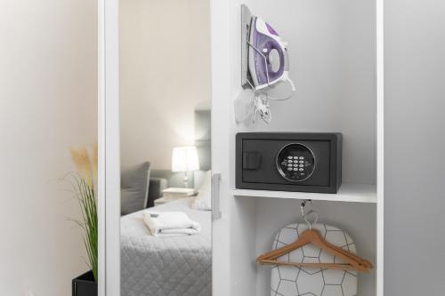 a small room with a bed and a microwave at Stawa Villa & Apart in Świnoujście