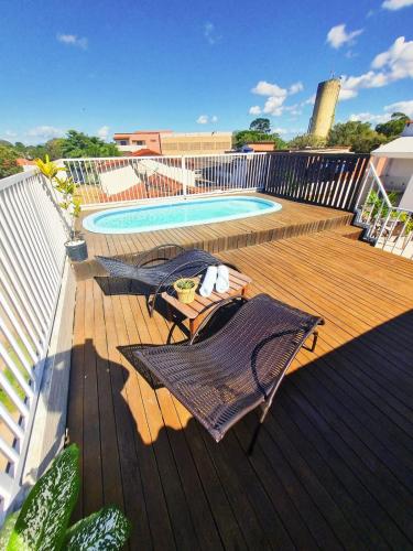 a deck with two chairs and a swimming pool at Pousada Coqueiral in Aracruz