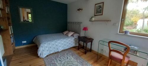 een slaapkamer met een bed, een tafel en een raam bij Chez Anne in Rennes