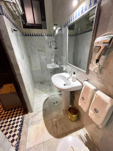 a bathroom with a sink and a toilet and a mirror at Le Grand Alcazar - Riad in Fès