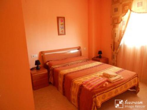 ein kleines Schlafzimmer mit einem Bett und einer Lampe in der Unterkunft Apartamento 1ª linea en Marina D´or, Oropesa del Mar in Oropesa del Mar