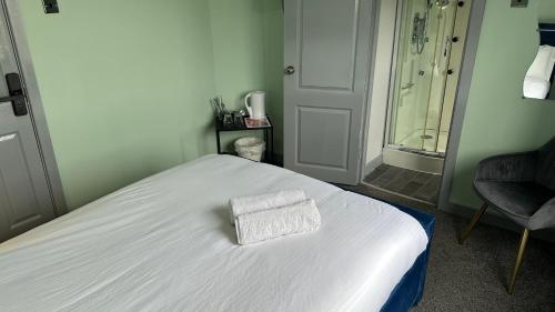 a white bed with a towel on it in a room at Homestay in Walsall in Walsall