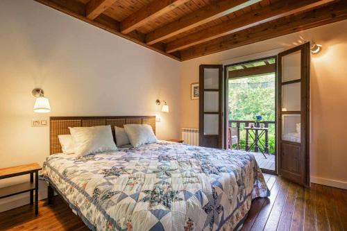a bedroom with a bed and a door to a patio at Casa escondida cuencu in Margolles