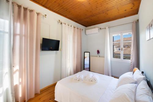 sypialnia z białym łóżkiem i oknem w obiekcie Lefkada white house w mieście Leukada (miasto)